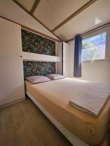 珀蒂蒂勒Les bungalows du chateau d'Ô的带一张大床和一扇窗户的卧室
