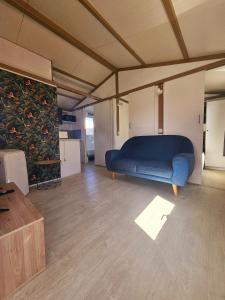 珀蒂蒂勒Les bungalows du chateau d'Ô的客厅里有一张蓝色沙发 更多37张照片