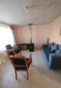 a living room with a blue couch and chairs at Refugio Yungay in Puerto Montt