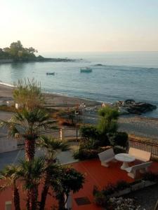 a view of a beach and the ocean with palm trees at Appartamento in Residence La Vela in Palizzi Marina +7 photos
