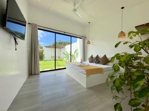 a bedroom with a bed and a large window at Pinya Villas Elnido in El Nido