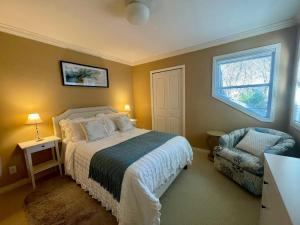 a bedroom with a bed and a chair and a window at Terra Nova - Private property in Richmond