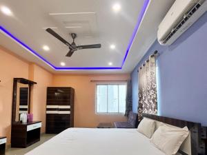 a bedroom with a bed and a ceiling with blue lights at Sunview Resort in Mandarmoni