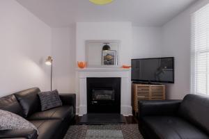 a living room with a couch and a fireplace at 'Fifteen' - Heritage Terrace in Battery Point in Hobart