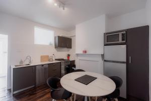 a small kitchen with a table and chairs in it at 'Fifteen' - Heritage Terrace in Battery Point in Hobart +62 photos
