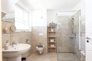 a bathroom with a shower and a toilet and a sink at In den Katen in Wieck +19 photos