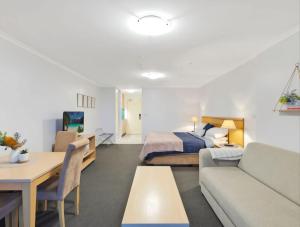 a hotel room with a bed and a couch at The Entrance Waterfront Resort, Unit 614 in The Entrance +2 photos