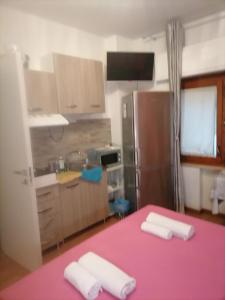 una cucina con tavolo rosa e asciugamani di Medea rooms palermo centro a Palermo