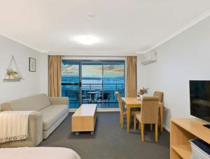a living room with a couch and a table at The Entrance Waterfront Resort, Unit 614 in The Entrance