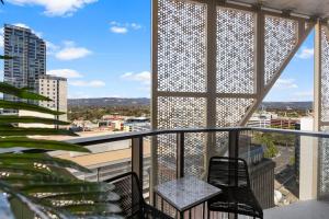 un balcon avec deux chaises et une table dans l'établissement Skyline Retreat - 2BR Luxury City Apartment, à Adélaïde