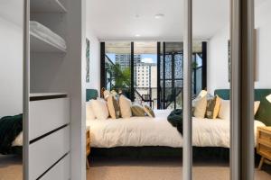 une chambre avec un lit et un miroir dans l'établissement Skyline Retreat - 2BR Luxury City Apartment, à Adélaïde