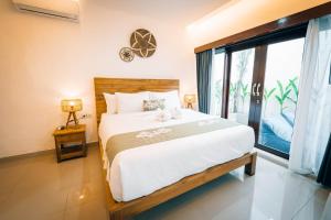 a bedroom with a large bed and a large window at Villa Umah Seminyak in Seminyak