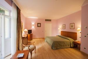 a bedroom with a bed and a table and a chair at Ateneo Garden Palace in Rome