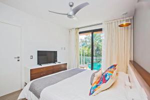 Lujoso junto a la 5th avenida 306 في بلايا ديل كارمن: غرفة نوم بها سرير ونافذة كبيرة