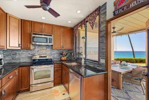 eine Küche mit Holzschränken und Blick auf das Meer in der Unterkunft Poipu Makai Villas C1 in Koloa