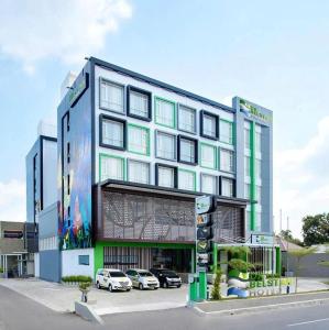 a large building with cars parked in front of it at DK Belstar Hotel Belitung in Tanjungpandan