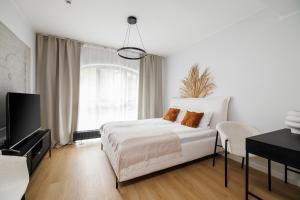 波兹南Aparthotel City Break Plac Wolności 6的一间带床和电视的白色卧室