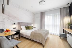 波兹南Aparthotel City Break Plac Wolności 6的一间卧室配有一张床和一张桌子及一碗水果