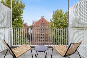 波兹南Aparthotel City Break Plac Wolności 6的一个带桌椅的阳台和一座建筑