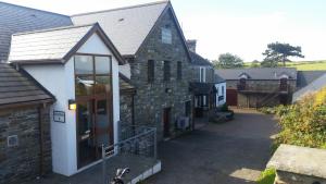 GowertonにあるThe Gower Golf Clubの車道に通じる小道のある大きな石造りの建物 +9枚の写真
