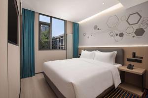 Rúm í herbergi á Microtel by Wyndham Xian Beilin