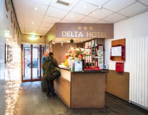 a man standing at the counter of a delia hotel at Delta Hotel City Center in Amsterdam