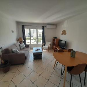 a living room with a couch and a table at Petit Coin de Paradis 2 MN de la mer 2chs balcon clim parking in Six-Fours-les-Plages