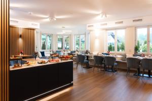 a restaurant with tables and chairs and windows at Boutiquehotel Drei Ringe Schwörstadt - Rheinfelden in Schwörstadt
