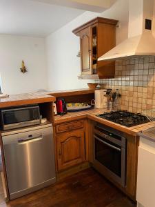 a kitchen with stainless steel appliances and wooden cabinets at Maison du Moulin in Maen Roch +4 photos