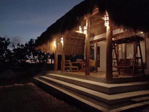a small house with a porch at night at Sumba Voyage Villa in Rua