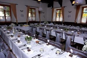 a banquet hall with long tables and chairs at Penzion Taferna in Žďár nad Sázavou