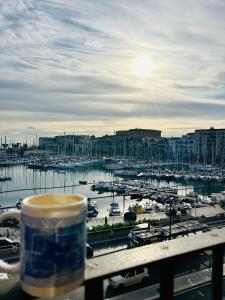 a cup of coffee sitting on a railing overlooking a marina at CalaMia in Palermo