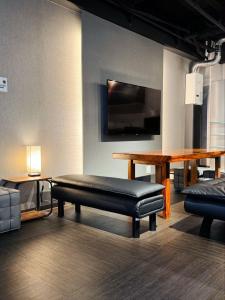 a room with a bench and a table and a tv at IKEBUKURO TOKIWA 10 BUILDING 6min walk from Ikebukuro Station Direct access to the airport in Tokyo