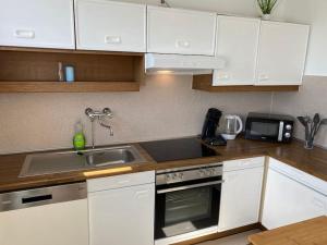 a kitchen with white cabinets and a sink and a microwave at Worker Place Kleve in Kleve