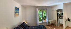a living room with a couch and a window at Sous les pins parasols in Vidauban