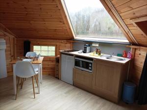 a kitchen with a sink and a window in a cabin at Kota 'Dans les étoiles' in Merlines
