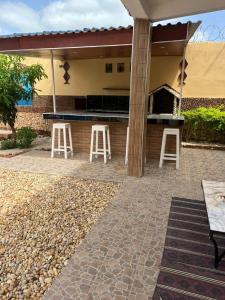 a patio with stools in front of a house at Sendou Cabano Villa Retreat in Siendou