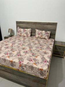 a bed with a floral comforter and two pillows at Sendou Cabano Villa Retreat in Siendou