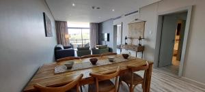 ein Wohnzimmer mit einem Holztisch und Stühlen in der Unterkunft Zimbali Suites 505 in Ballito