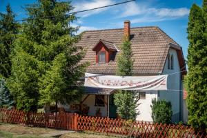 a house with a banner in front of it at Mazsola Vendégház in Tamási