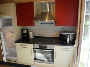 a small kitchen with a stove and a microwave at Hagebutte - Baabe in Baabe