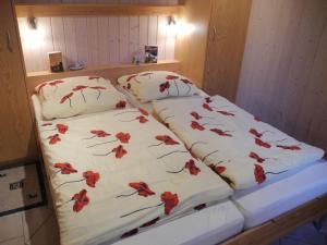 two beds in a room with red flowers on them at Hagebutte - Baabe in Baabe