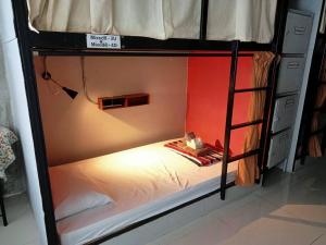 a small bed in a bunk bed with a ladder at O'Kane's Pub and Hostel in Chiang Rai