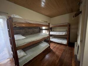 two bunk beds in a room with wooden floors at Hotel Nativo in Santiago