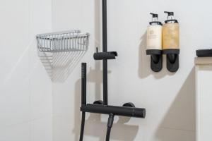a bathroom with a rack with hair products on the wall at Beach Walk Boutique Jumeirah in Dubai