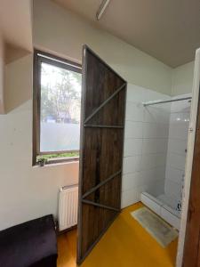 a bathroom with a wooden door and a window at Hotel Nativo in Santiago