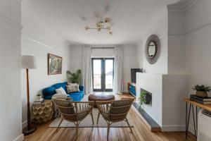a living room with two chairs and a blue couch at Modern 3-Bed Coastal Escape in Burnie