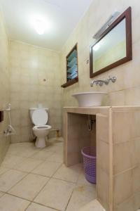 a bathroom with a sink and a toilet at Pontoon Residences & Suites in Mombasa