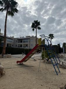 a playground with a slide in the sand with palm trees at Arting Sea-A Dog friendly house in Khlorakas