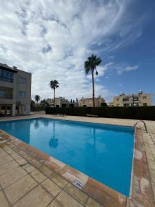 a large blue swimming pool with palm trees at Arting Sea-A Dog friendly house in Khlorakas